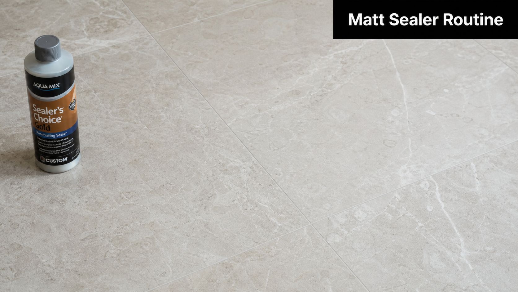 A bottle of Aqua Mix Sealer's Choice Gold sealer standing on light beige marble floor tiles.